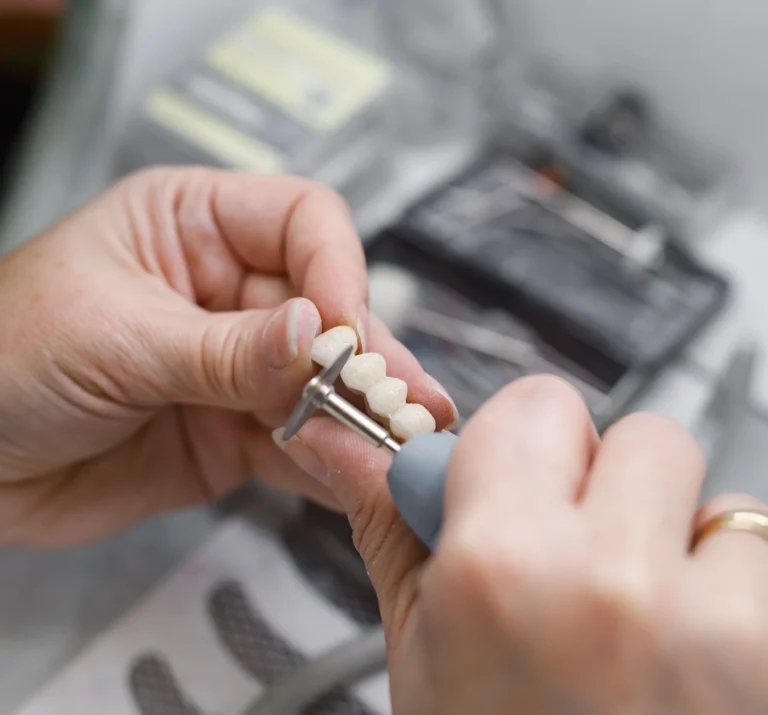 Dental technician shaping prosthetic